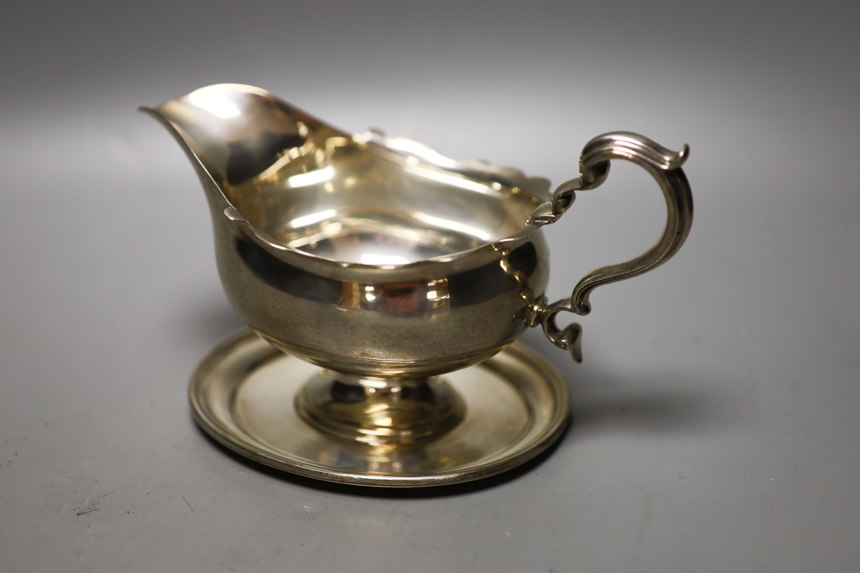 An Edwardian silver pedestal sauceboat on oval base, Thomas Bradbury & Sons, London, 1907, width 19.5cm, 140z.